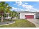 A charming single-story home features a well-manicured lawn, palm trees, and a two-car garage at 3839 Manor Oaks Ct, Leesburg, FL 34748