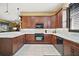 L-shaped kitchen with dark wood cabinets and marble counters at 3839 Manor Oaks Ct, Leesburg, FL 34748