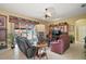 Spacious living room featuring tile floors, ceiling fan and sliding doors to the outdoor screened in area at 3839 Manor Oaks Ct, Leesburg, FL 34748