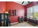 Home office with red walls, built-in shelving, and window at 3839 Manor Oaks Ct, Leesburg, FL 34748