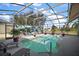 The inviting screened-in pool area features a waterfall mural and space for relaxation and entertainment at 3839 Manor Oaks Ct, Leesburg, FL 34748
