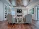 Spacious living room features hardwood floors, a fireplace, built-in shelving, and a coffered ceiling at 640 Ternberry Forest Dr, The Villages, FL 32162