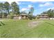 Two-building property view with large grassy front yard and mature trees at 703 & 705 Cleveland Ave, Wildwood, FL 34785