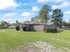 Ranch style home with large backyard, wooden fence, and mature trees at 703 & 705 Cleveland Ave, Wildwood, FL 34785