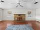 Spacious living room featuring hardwood floors and a stone fireplace at 703 & 705 Cleveland Ave, Wildwood, FL 34785