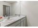 Bathroom with double vanity and light gray cabinets at 8511 Triumph Cir, Wildwood, FL 34785