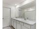 Bright bathroom featuring a double vanity and a large mirror at 8511 Triumph Cir, Wildwood, FL 34785