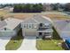 Two-story house with gray siding, gray roof, and a two-car garage at 8511 Triumph Cir, Wildwood, FL 34785