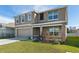 Two story house with a two car garage and landscaping at 8511 Triumph Cir, Wildwood, FL 34785