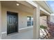 Covered front porch with black front door and white columns at 8511 Triumph Cir, Wildwood, FL 34785