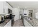 Modern kitchen with white cabinets, granite countertops, and stainless steel appliances at 8511 Triumph Cir, Wildwood, FL 34785