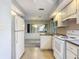 White appliances and cabinets in this galley kitchen at 100 E Golf Links Ave, Eustis, FL 32726