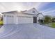 Two-car garage with decorative driveway and landscaping at 1060 Maynard Path, The Villages, FL 32163