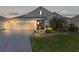 House exterior with a two-car garage and evening lighting at 1060 Maynard Path, The Villages, FL 32163