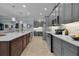 Modern kitchen with gray cabinets, quartz countertops, and a breakfast bar at 1060 Maynard Path, The Villages, FL 32163