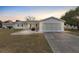 Single story home with a paved driveway and a well-maintained lawn at 10662 Se 174Th Loop, Summerfield, FL 34491