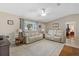 Open living room with beige leather sofas and a view to the bedroom at 10662 Se 174Th Loop, Summerfield, FL 34491