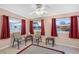 Sunroom with ceiling fan and red curtains, access to backyard at 10662 Se 174Th Loop, Summerfield, FL 34491