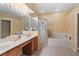 Primary bathroom with a double vanity, shower, and soaking tub at 1070 Bentry Ct, Clermont, FL 34711