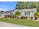 Light gray house with white shutters, palm trees, and well-manicured lawn at 11631 Sw 82Nd Ter, Ocala, FL 34481