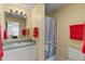 Bathroom with shower, vanity sink, and red towels at 1330 Lajolla Cir, The Villages, FL 32159