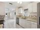 Bright kitchen features white cabinetry, granite countertops, stainless steel appliances, and tile flooring at 1330 Lajolla Cir, The Villages, FL 32159