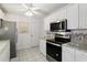 Well-lit kitchen features stainless steel appliances, white cabinetry, and granite countertops at 1330 Lajolla Cir, The Villages, FL 32159