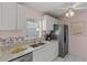 This kitchen showcases white cabinetry, a stainless steel refrigerator, and granite countertops at 1330 Lajolla Cir, The Villages, FL 32159