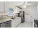 Well-equipped kitchen with white cabinets, granite counters, and stainless steel appliances at 1330 Lajolla Cir, The Villages, FL 32159