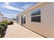 Tan house exterior with sliding glass doors leading to a concrete patio at 1387 Zest Ave, The Villages, FL 32163