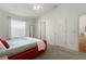 Well-lit bedroom with a red platform bed and ensuite bathroom at 1387 Zest Ave, The Villages, FL 32163
