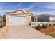 House exterior with a two-car garage and picket fence at 1387 Zest Ave, The Villages, FL 32163