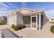 Screened porch adjacent to a tan house and two-car garage at 1387 Zest Ave, The Villages, FL 32163