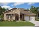 Two-story house with beige exterior, white garage doors, and landscaping at 14422 Crest Palm Ave, Windermere, FL 34786