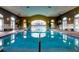 Indoor swimming pool with large windows and seating area at 172 Crepe Myrtle Dr, Groveland, FL 34736