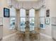 Kitchen nook with glass table, chairs, and bay window overlooking backyard at 172 Crepe Myrtle Dr, Groveland, FL 34736