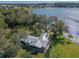 Aerial view of a home on the lake with expansive green space and a metal roof at 17531 County Road 455, Montverde, FL 34756