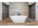 Modern bathroom with freestanding soaking tub and stone wall at 17531 County Road 455, Montverde, FL 34756