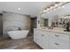 Elegant bathroom with soaking tub, double vanity, and stone feature wall at 17531 County Road 455, Montverde, FL 34756