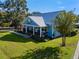 Blue house with metal roof, porch, and landscaping at 17531 County Road 455, Montverde, FL 34756