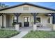 Front porch with black support beams, a rustic wood accent piece and landscaping at 17531 County Road 455, Montverde, FL 34756