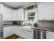 Modern kitchen featuring white cabinets, stainless steel appliances, and grey countertops at 17531 County Road 455, Montverde, FL 34756
