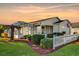 Charming single-story home featuring a manicured lawn, white picket fence, and an enclosed patio, all bathed in the warm glow of sunset at 202 Estrada Pl, The Villages, FL 32159