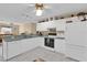Bright kitchen with white cabinets, appliances, and breakfast bar at 202 Estrada Pl, The Villages, FL 32159
