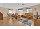Open living room with leather sofas, wood floors, and view to dining area at 202 Estrada Pl, The Villages, FL 32159