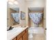 Bathroom with tub shower, vanity, and linen storage at 2131 Baldwin Run, The Villages, FL 32162