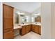 Double vanity bathroom with wood cabinets and tile flooring at 2131 Baldwin Run, The Villages, FL 32162