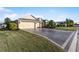 Tan two-story house with attached garage and landscaped yard at 2131 Baldwin Run, The Villages, FL 32162