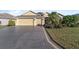 Two-story house with a three-car garage and palm trees at 2131 Baldwin Run, The Villages, FL 32162