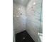 The bathroom has a glass-enclosed shower stall with modern fixtures and black, honeycomb-patterned flooring at 2137 Sunshine Peak Dr, Minneola, FL 34715